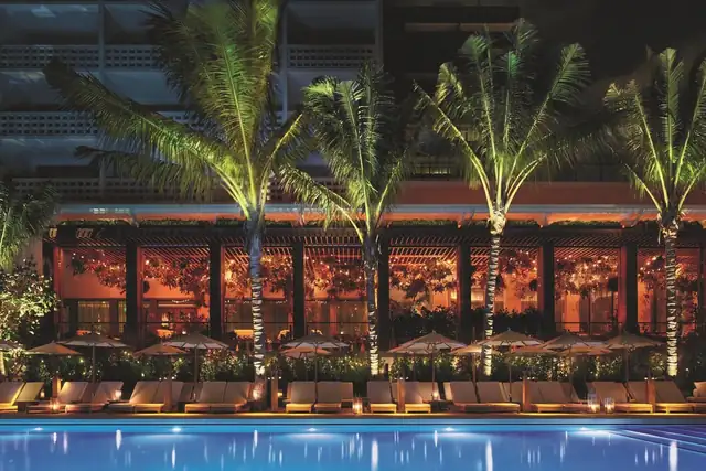 The Miami Beach EDITION in Miami, pool area with lounge chairs and umbrellas