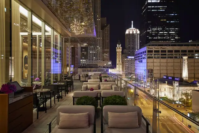 The Peninsula Chicago in Chicago, rooftop terrace bar with night view of skyline