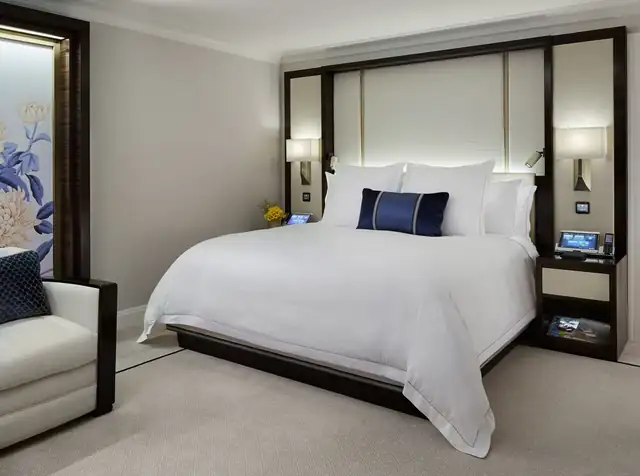The Peninsula Chicago in Chicago, made bed with white linens and a dark headboard