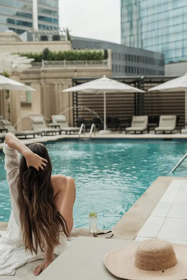 The Ritz-Carlton in Dallas, pool area with loungers, umbrellas and a seated person