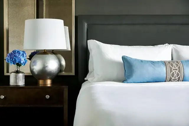 The Ritz-Carlton Tysons Corner in McLean, neatly made bed with white and blue linens