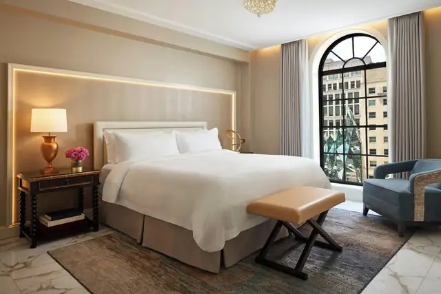 St. Regis Washington in Washington, DC, room with white-linen bed and bench